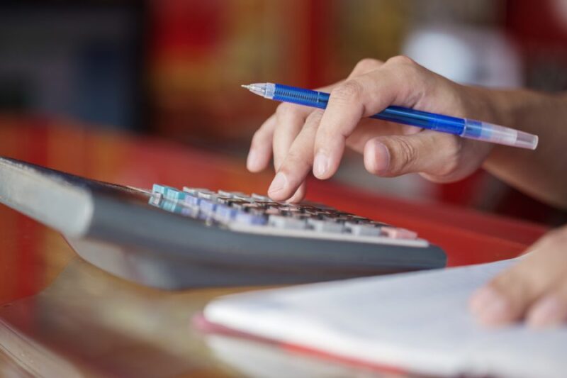 homem usando calculadora para ilustrar texto sobre gastos de eventos