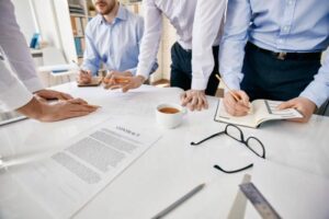 profissionais analisando documentos para ilustrar texto sobre reuniões de negócios