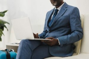 executivo sentado com laptop para ilustrar texto sobre segurança em viagens