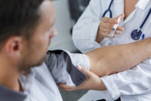 pessoa tomando vacina para ilustrar texto sobre vacinação para viagens internacionais