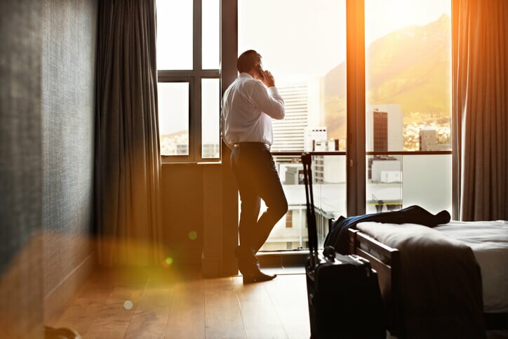 homem em quarto de hotel para ilustrar texto sobre como economizar com hospedagem
