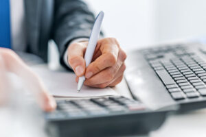 homem escrevendo para ilustrar texto sobre expense management controlar despesas