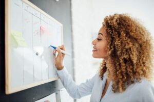 mulher escrevendo em um quadro para ilustrar texto de calendario de eventos