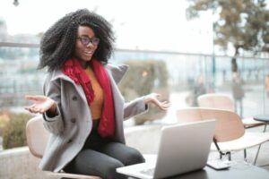 mulher assistindo vídeo no notebook para ilustrar texto sobre eventos híbridos