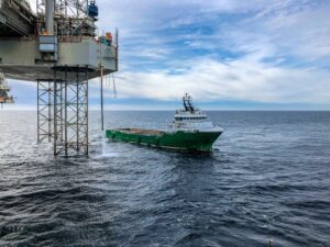 Navio ao lado de uma plataforma de petróleo para ilustrar texto de gestão estratégica de custos em offshore