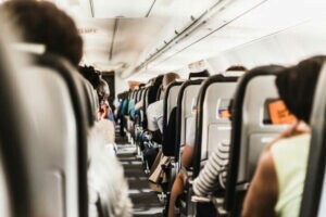 passageiros dentro do avião para ilustrar texto sobre política de viagens corporativas