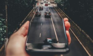Imagem de uma mão segurando uma pista com carro para ilustrar texto sobre Mobility as a Service