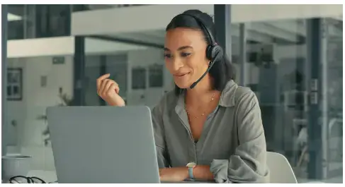 atendente com fone e olhando para o notebook para ilustrar texto sobre atendimento 24-7
