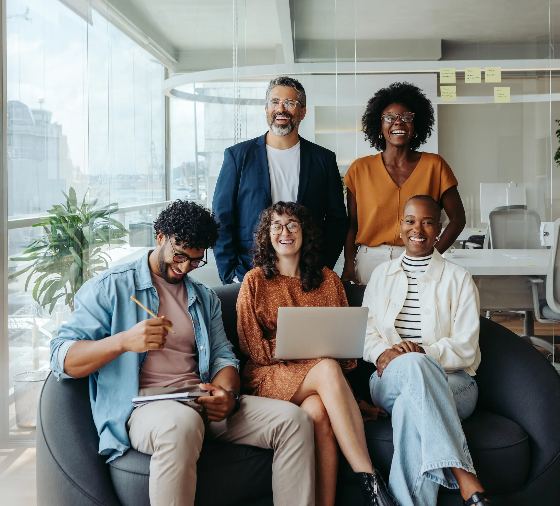 Equipo diverso y sonriente en una oficina moderna, que representa el cuidado de las personas