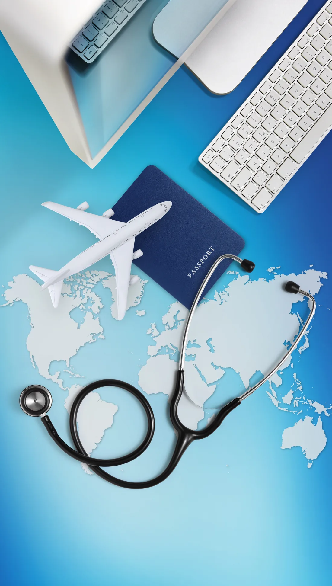 Passaporte, avião de brinquedo e estetoscópio sobre um mapa-múndi, com teclado e monitor ao fundo