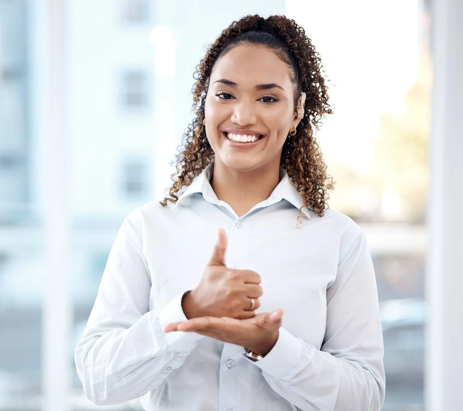 Mujer sonriente comunicándose en lengua de señas